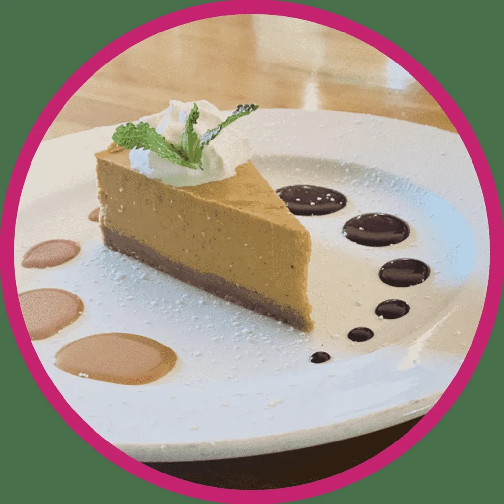 Creamy dessert slice with whipped cream, mint, and sauces.
