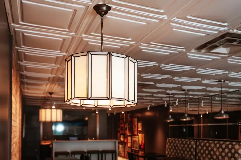 Restaurant interior with large polygonal chandelier and pressed-tin ceiling.
