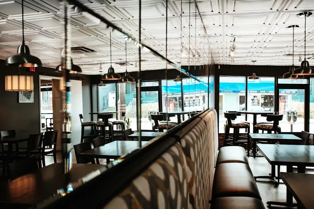 Empty modern restaurant interior with patterned booth and urban street view.