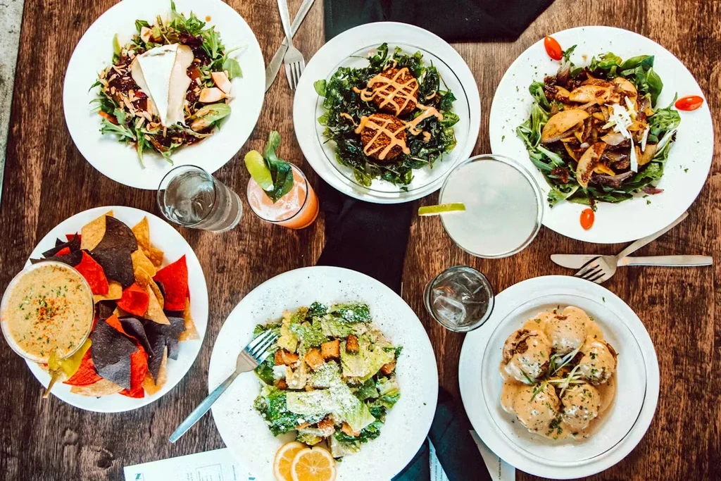 Overhead flat lay of a rustic table with diverse meals and drinks.