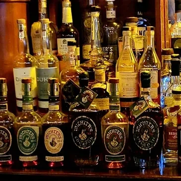 Warmly lit bar shelves stocked with Michter's and other spirits.