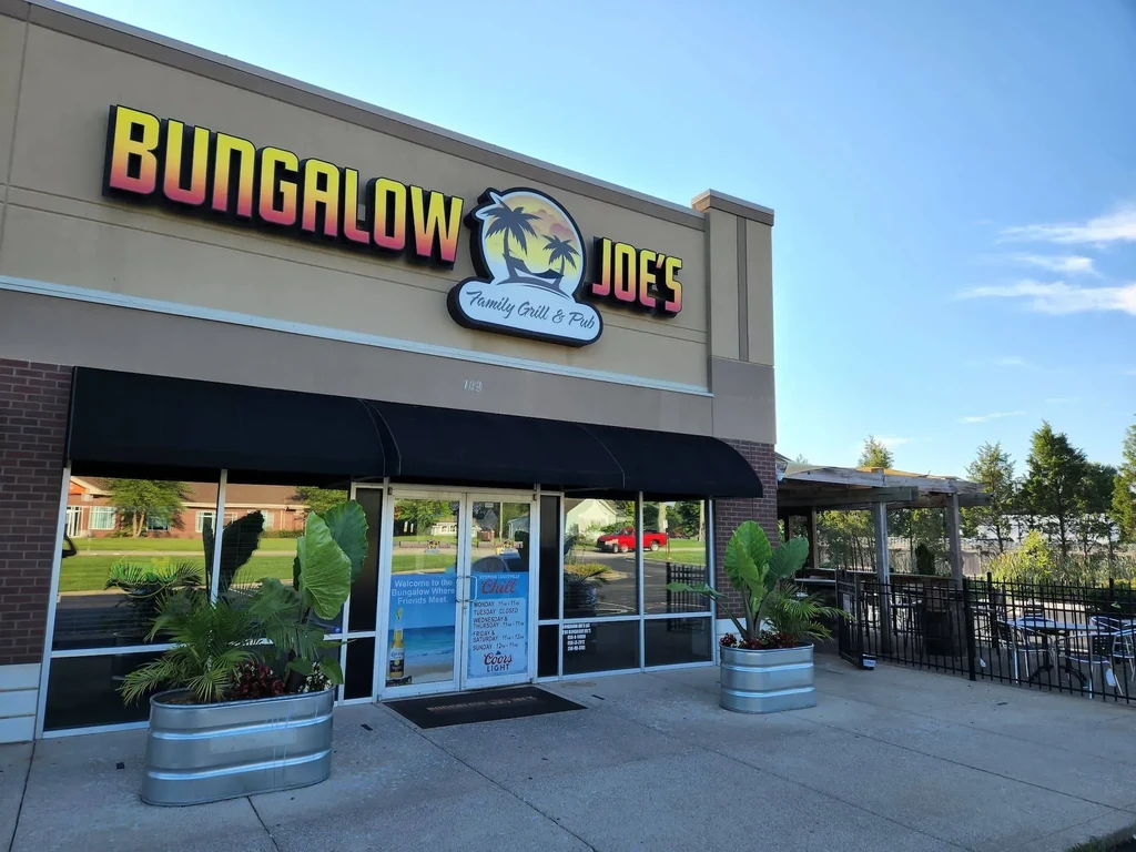 Bungalow Joe's restaurant facade with sign, tropical plants, and patio.