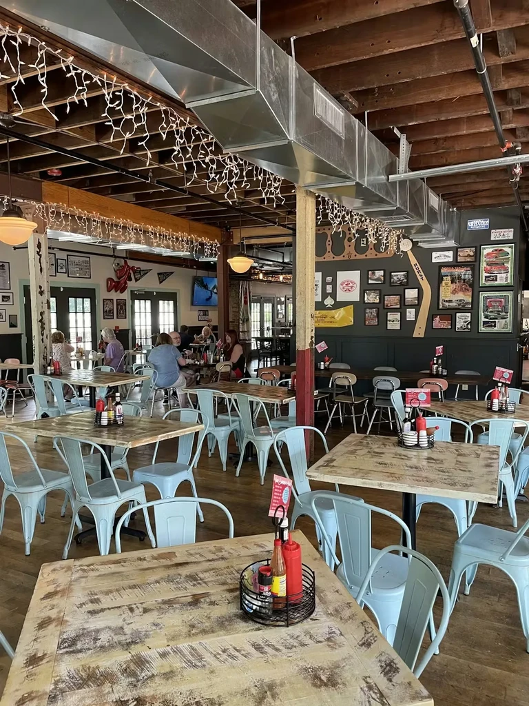 Lively casual restaurant with light blue metal chairs and string lights.