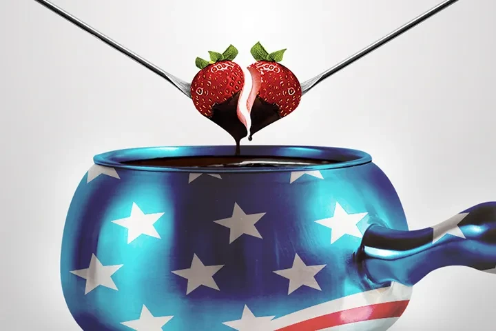 Forks hold chocolate-dipped strawberry heart dripping into patriotic star bowl.