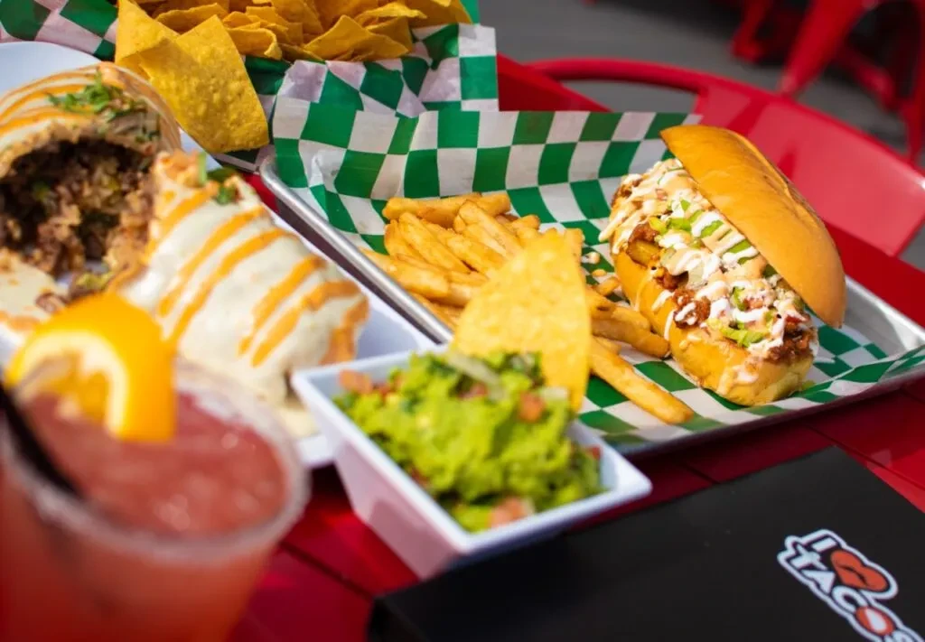 Assorted Mexican-inspired food and drink on a bright red table.