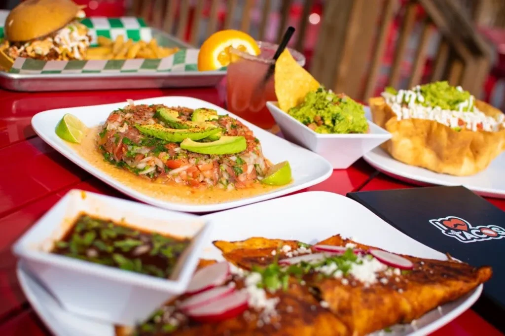 Mexican food spread featuring ceviche, a taco, guacamole, and a cocktail.