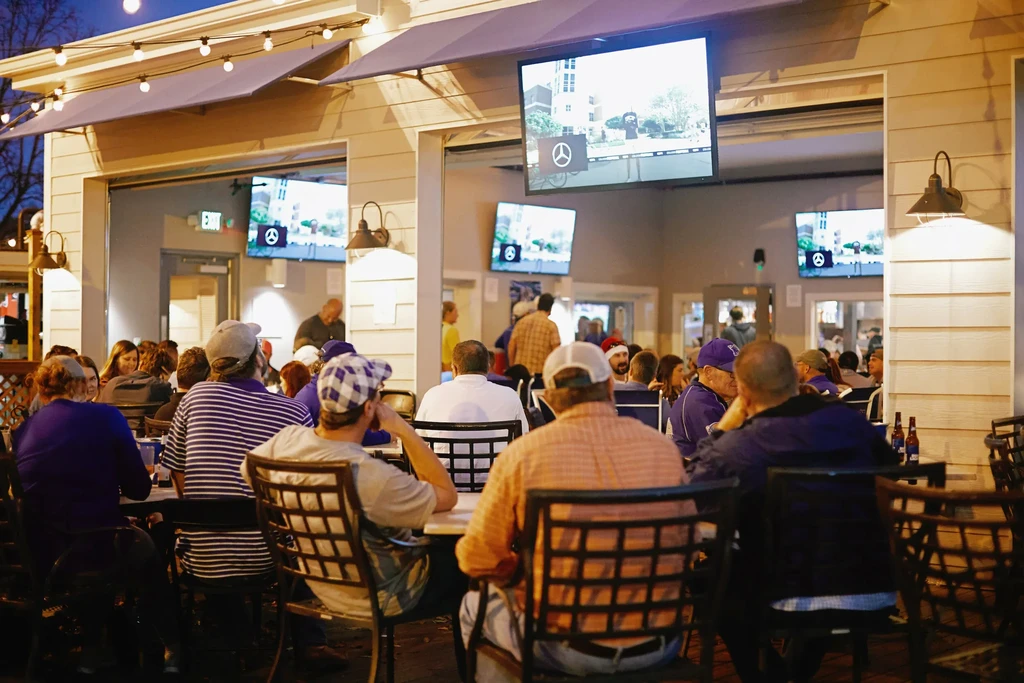 Bustling outdoor and semi-indoor dining and bar at night.