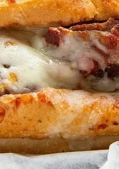 Gooey melted cheese and meat filling in a toasted sub cross-section.