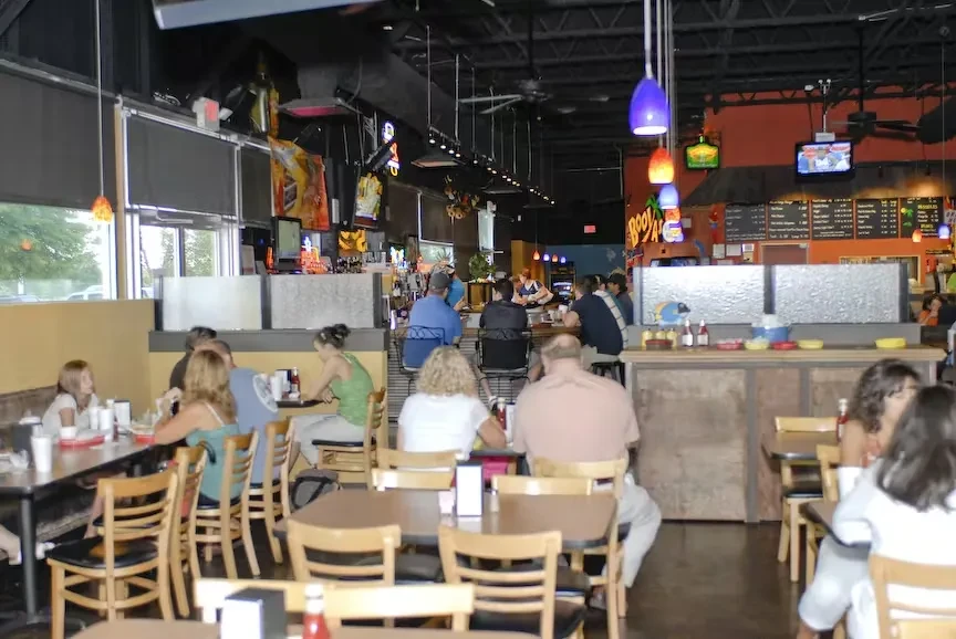 Lively casual restaurant interior with people dining and colorful decor.