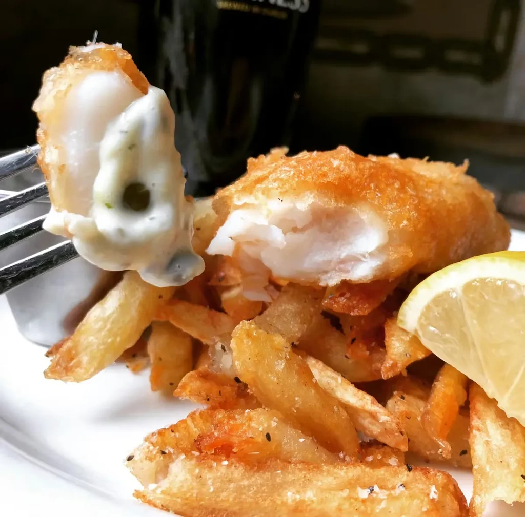 Crispy fried fish and chips with tartar sauce and lemon.