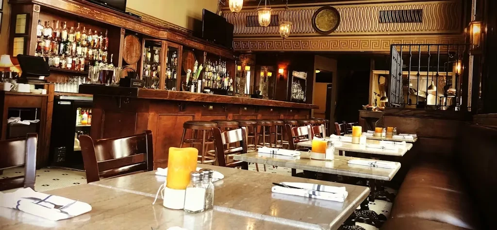 Wide-angle view of an empty, classic restaurant bar with ornate details.