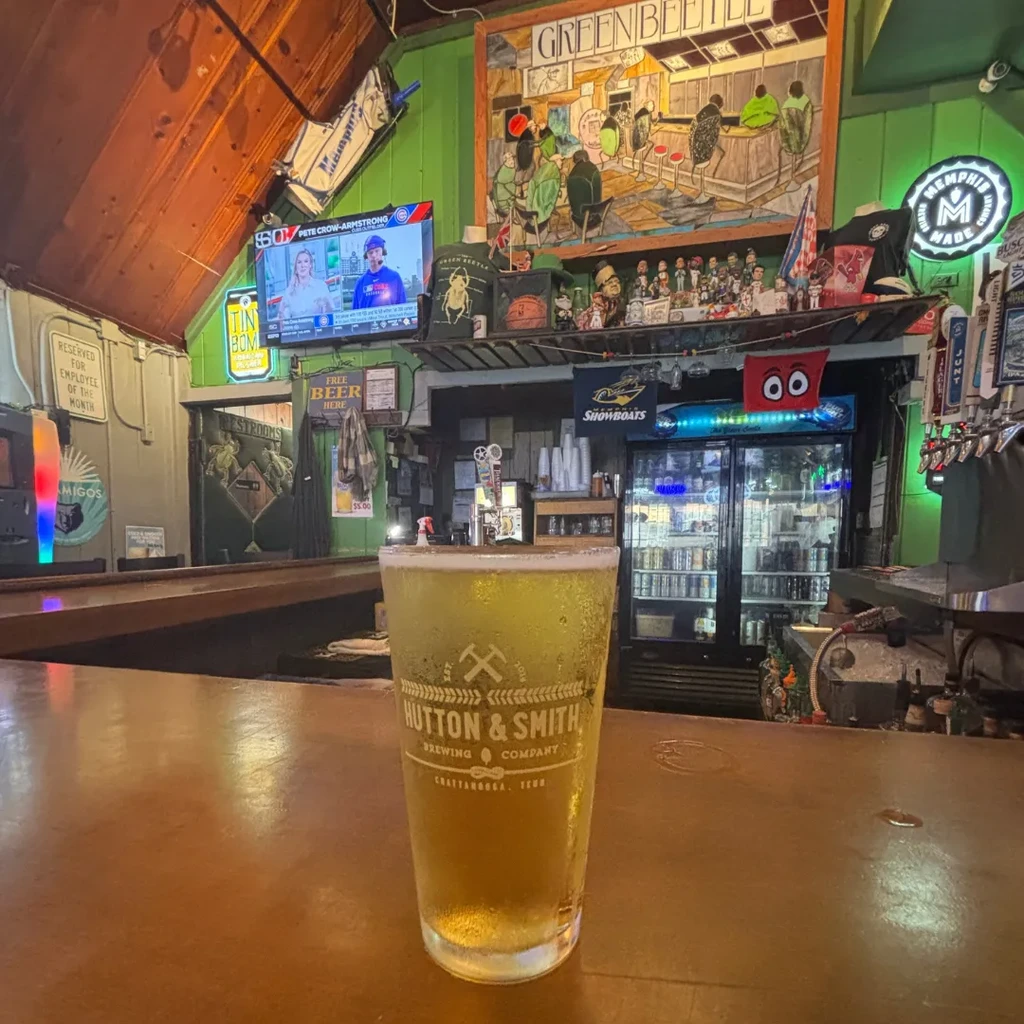 Condensation-covered Hutton & Smith beer glass on a casual bar.