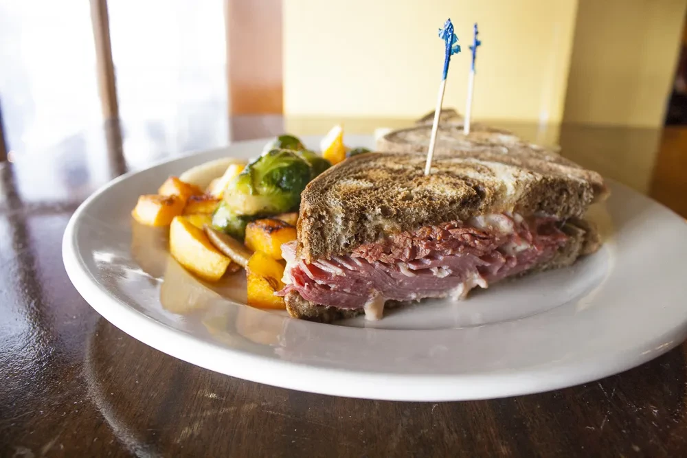 Pastrami sandwich with roasted squash and Brussels sprouts.