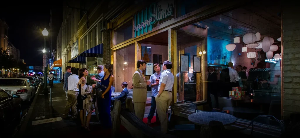 Night view of Bongo Slim's bar, people gathered outside the entrance.