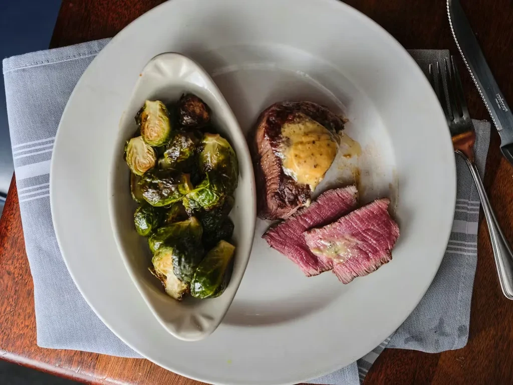 Top-down view of plated steak and roasted Brussels sprouts.