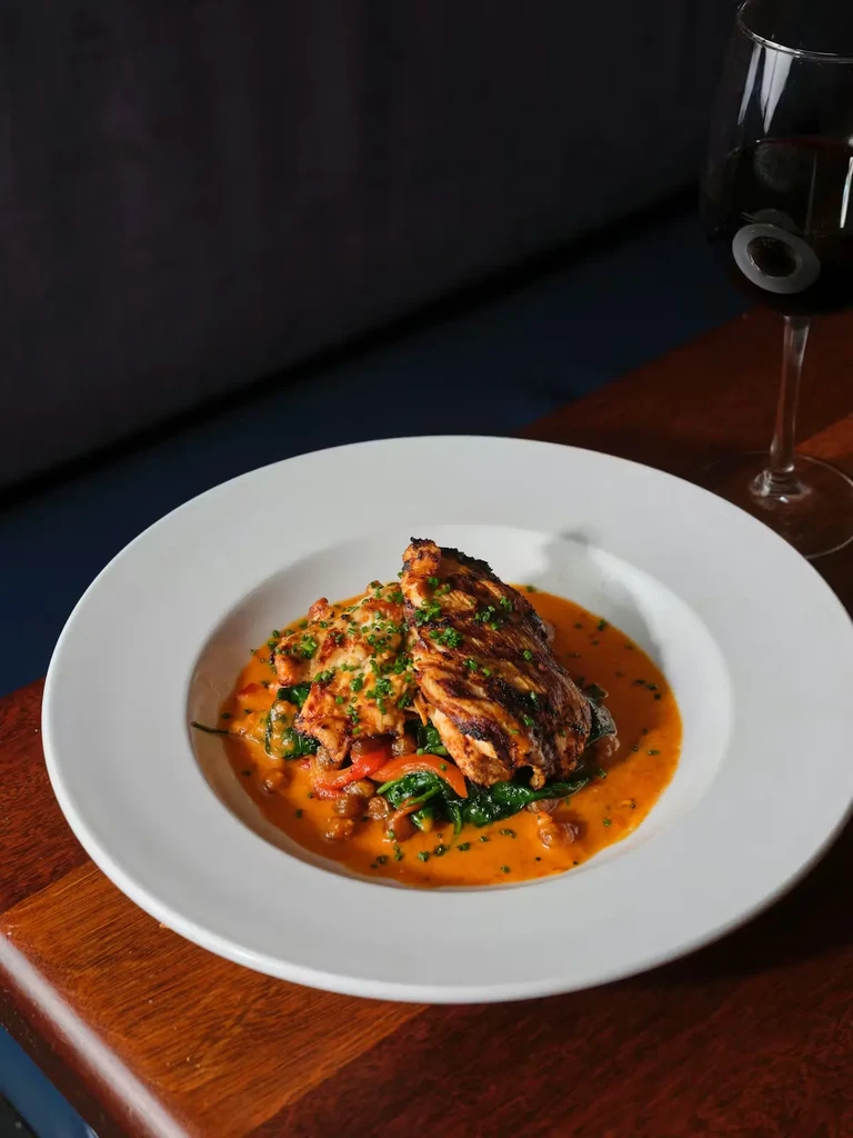 Grilled chicken/fish with spinach, creamy orange sauce, and red wine.