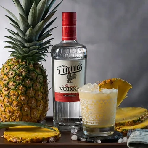 Old Dominick vodka, whole pineapple, and garnished tropical cocktail.