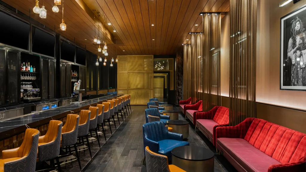 Modern upscale bar and lounge with dark marble counter and diverse seating.