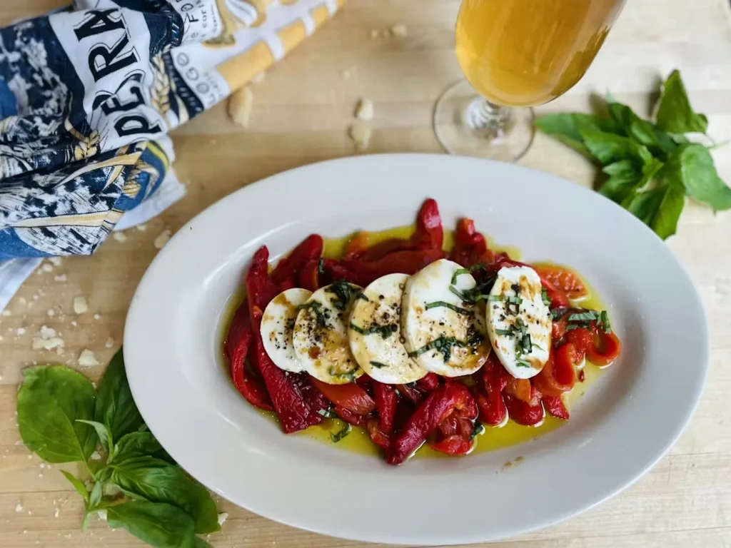 Roasted red peppers, fresh mozzarella, basil, and olive oil dish.