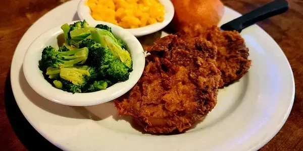 Fried food, broccoli, macaroni and cheese, and a bun on a plate.