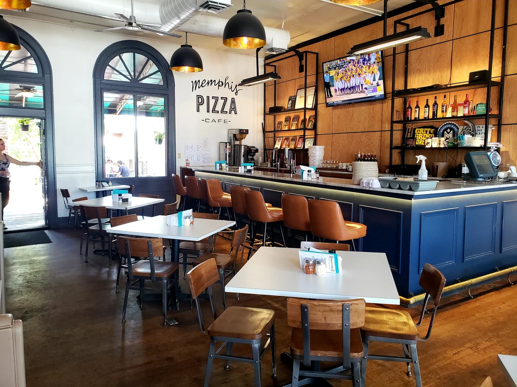 Memphis Pizza Cafe interior with a modern bar and lively dining area.