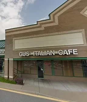Gus' Italian Cafe storefront: light brown brick, beige sign, green windows.