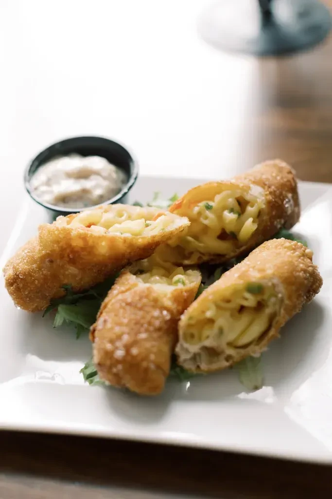 Crispy deep-fried macaroni and cheese rolls with dipping sauce.