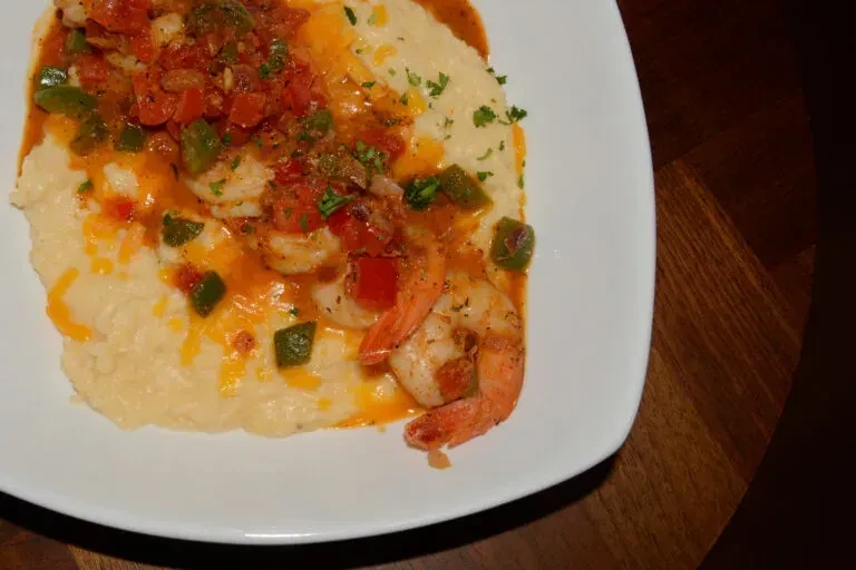 Cheesy grits topped with shrimp, tomatoes, green peppers, and herbs.