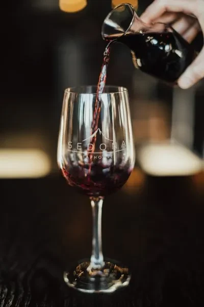 Red wine poured from carafe into a Sedona Tap House glass.