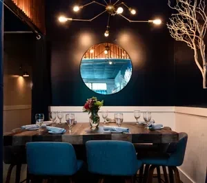 Sophisticated restaurant dining room with a set table and striking chandelier.