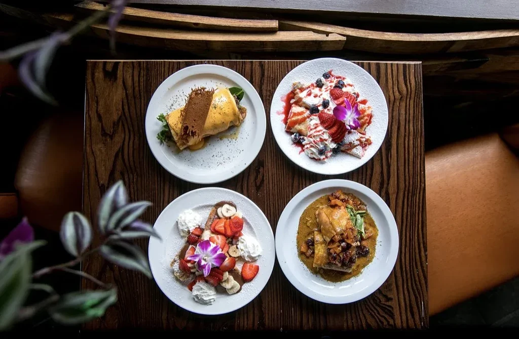 Four distinct sweet and savory dishes arranged on a dark wooden table.