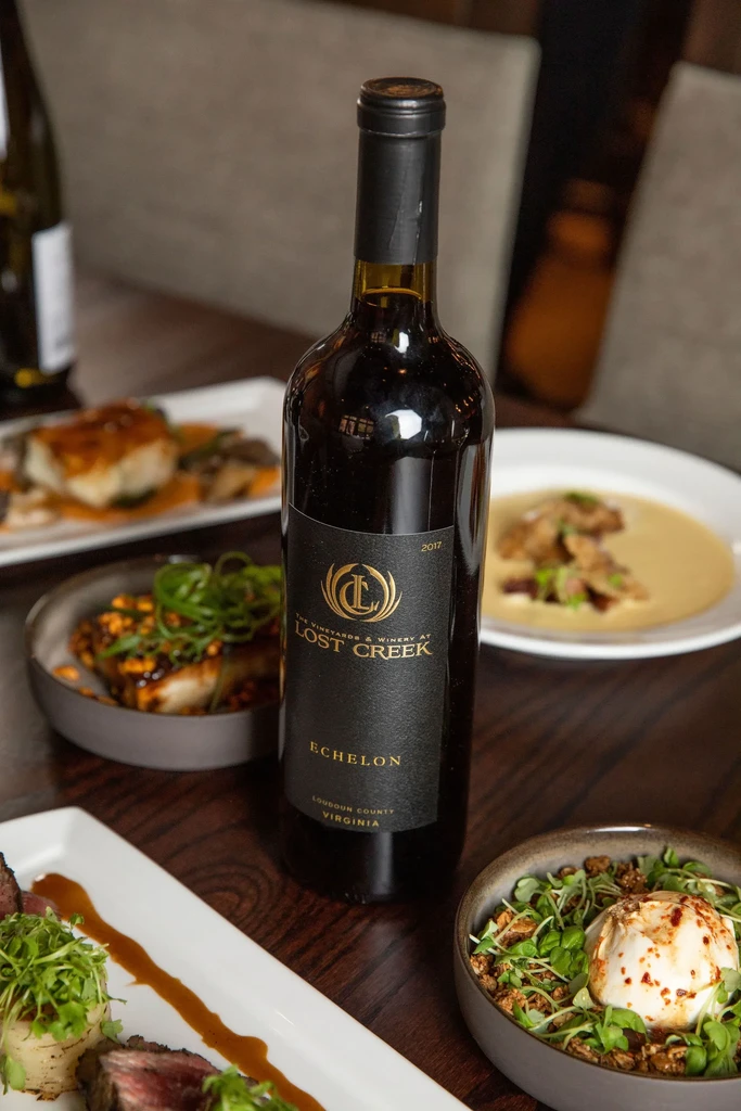 Lost Creek Echelon 2017 wine bottle on table with elegant food.