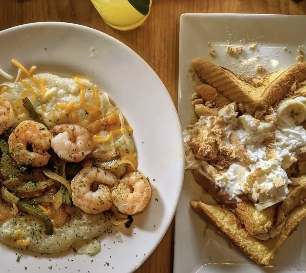 Overhead view of shrimp and grits, French toast, and a drink with lime.