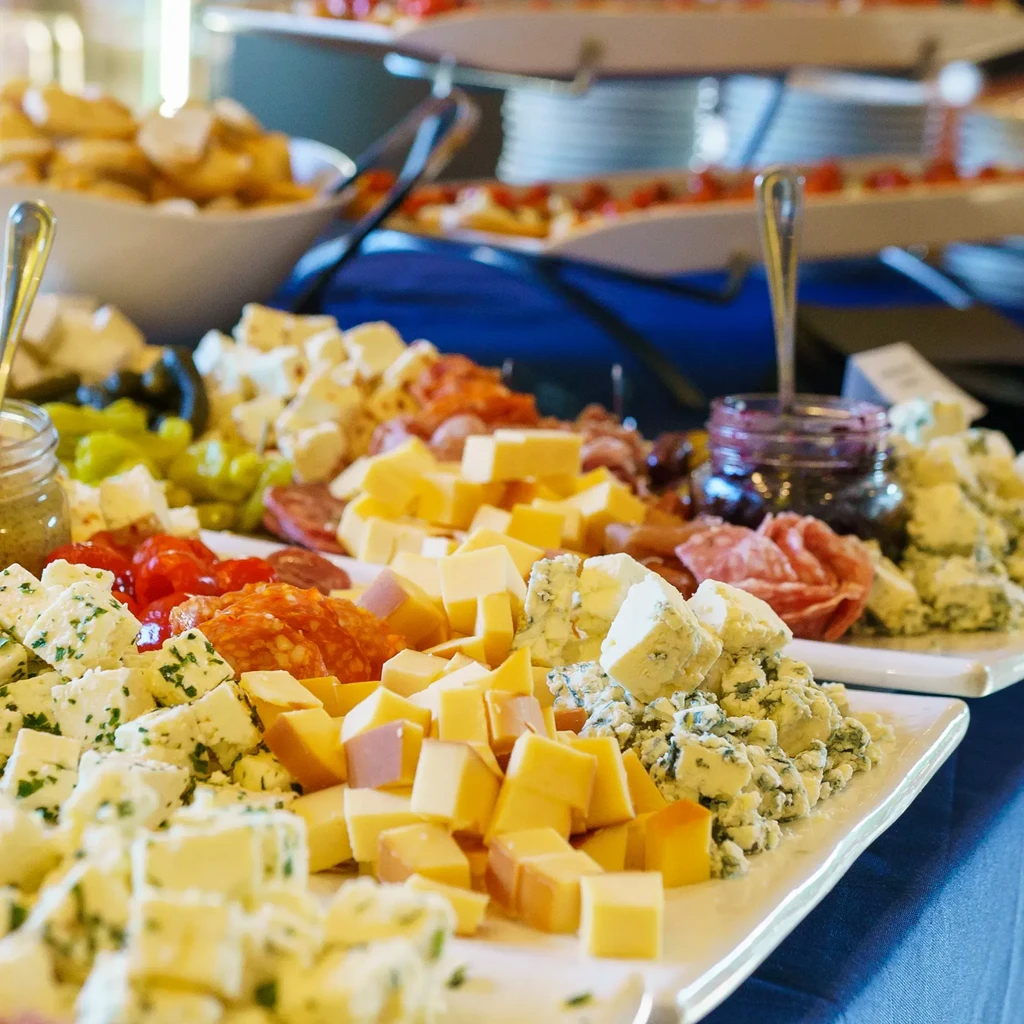 Buffet table with a spread of cheeses, charcuterie, and appetizers.