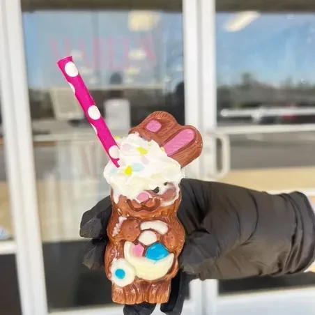 Chocolate bunny dessert with colorful basket, whipped cream, sprinkles, and straw.