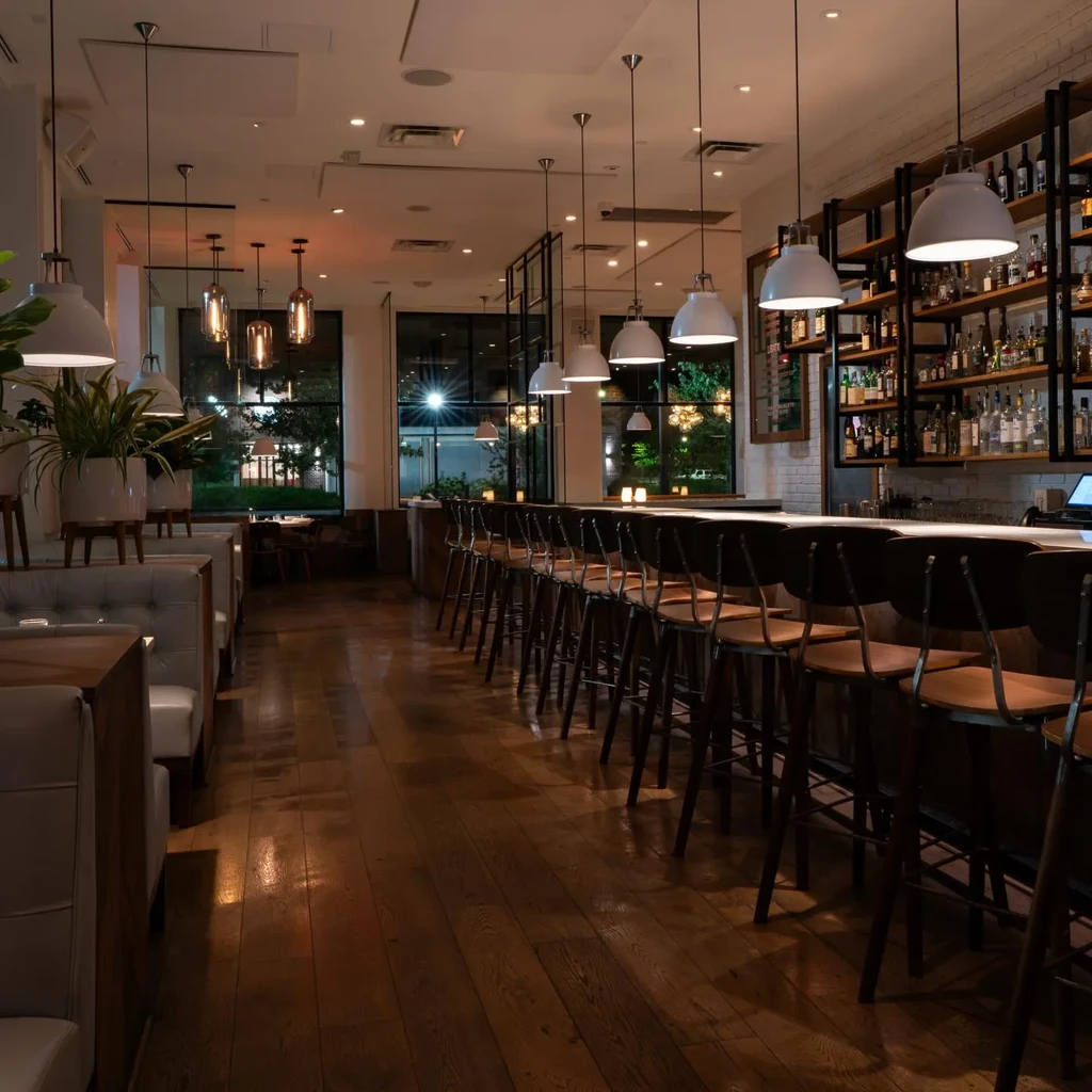 Empty, elegant bar interior with plush booths and a long bar.