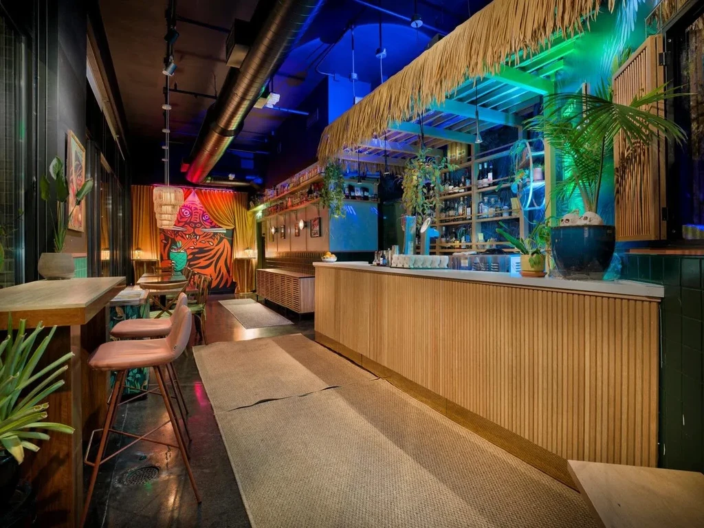 Vibrant tropical restaurant bar with neon lights and a prominent tiger mural.