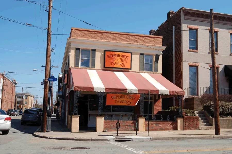 Sheppard Street Tavern, brick building with striped awning on sunny corner.