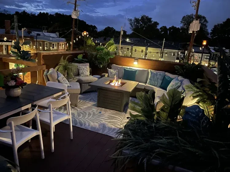 Sophisticated outdoor patio with fire pit, L-shaped lounge, and dining table.