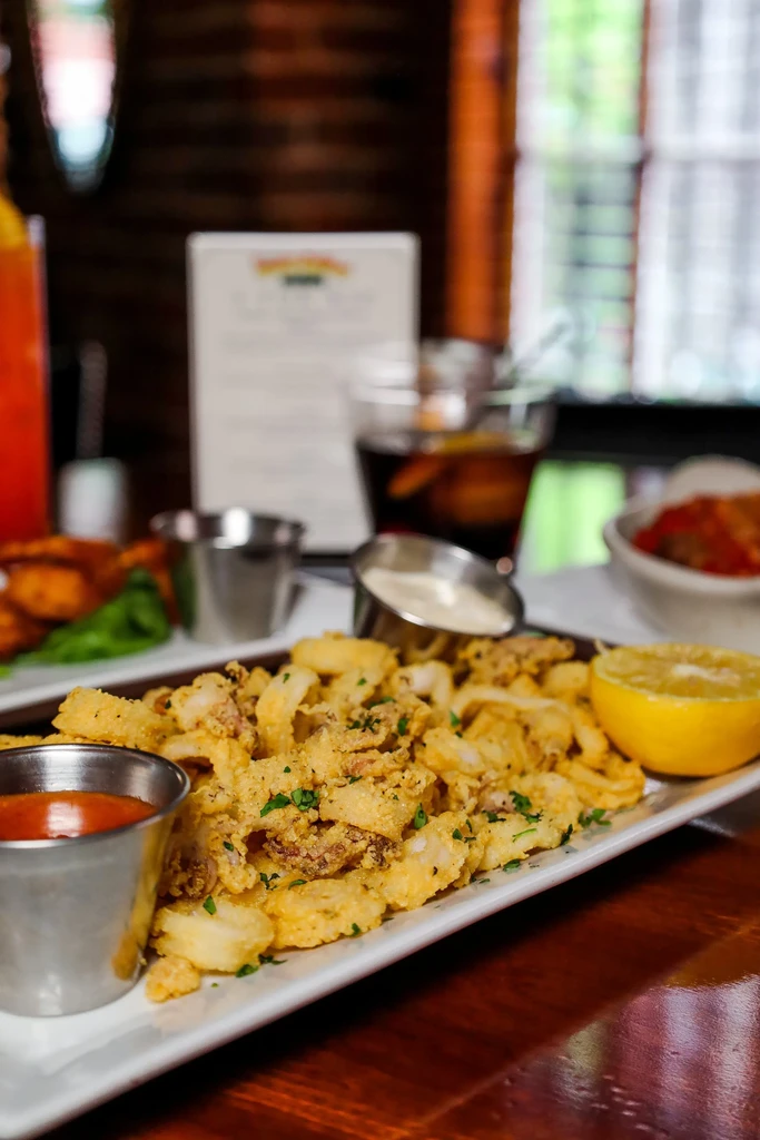 Golden-brown fried calamari with parsley, lemon, and two dipping sauces.