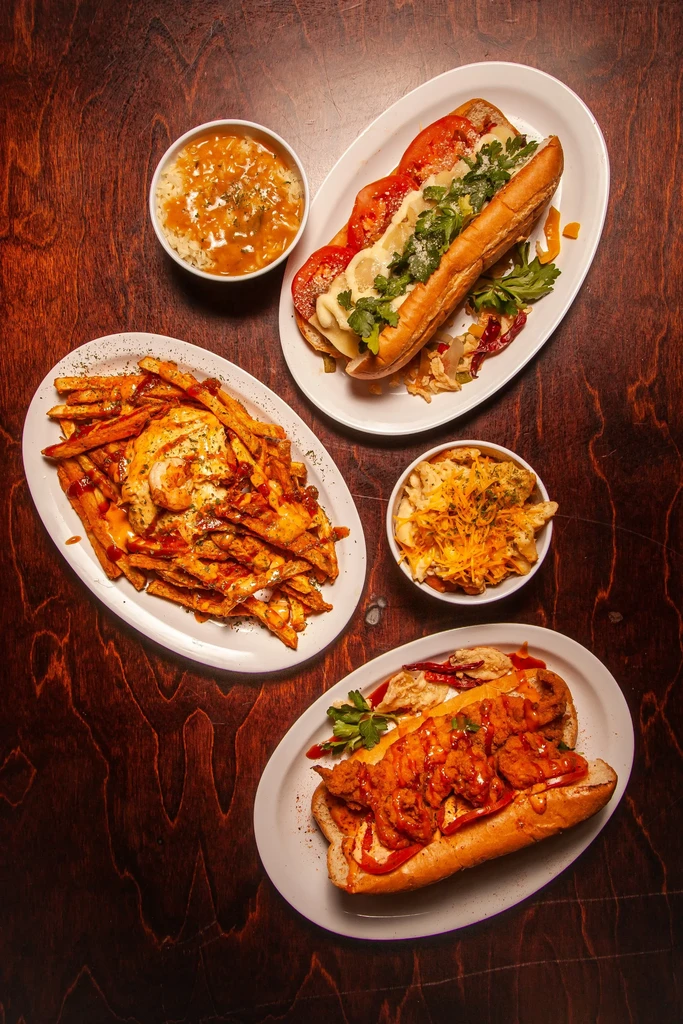 Assorted sandwiches, fries, mac and cheese, and stew on a table.