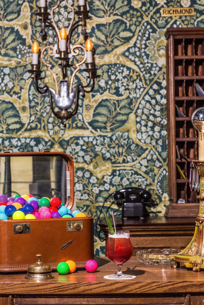 Red cocktail, golf balls, and ball pit balls on a reception counter.