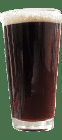 Close-up of a dark beer in a pint glass with a thick foam.