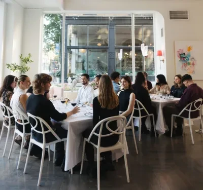 Large group enjoys a communal meal in a bright, modern restaurant.