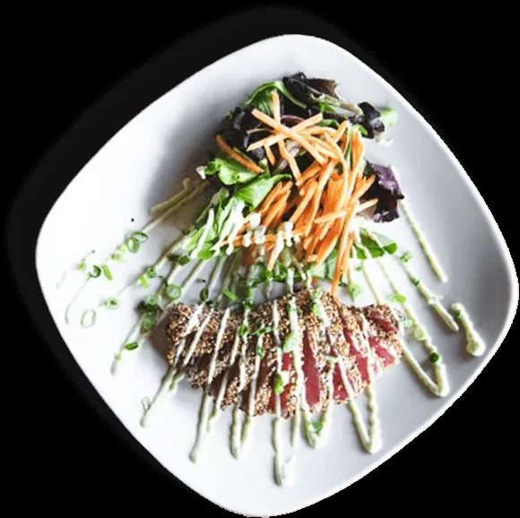 Seared Ahi tuna with sesame crust, green salad, and sauce.