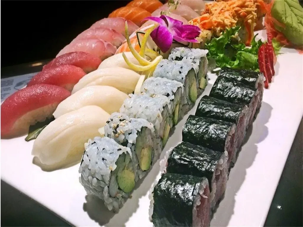 Large platter of sushi and sashimi with nigiri, rolls, and garnishes.