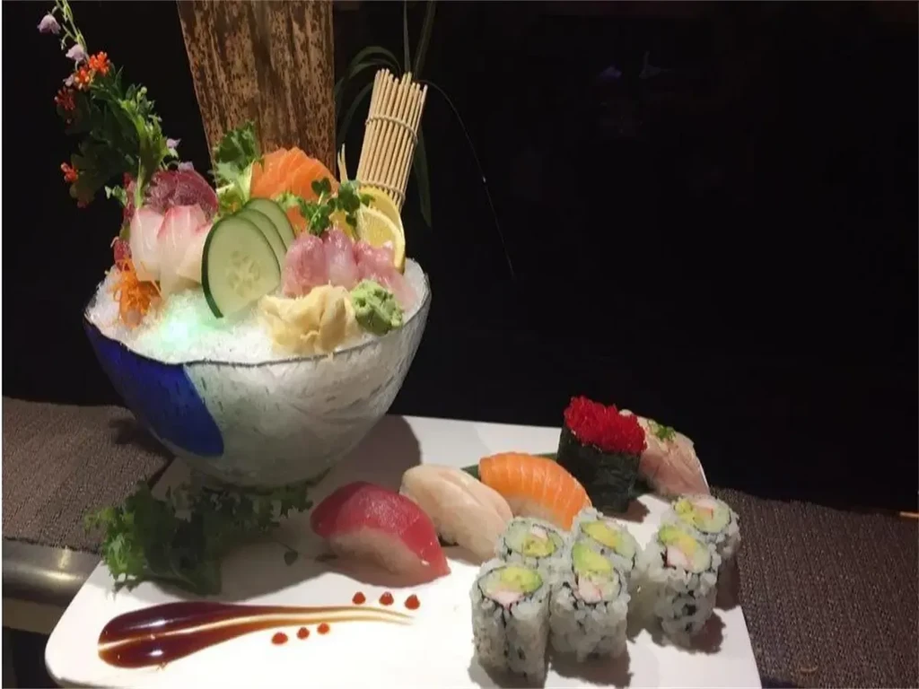 Assorted Japanese sushi and sashimi platter with glowing ice bowl.