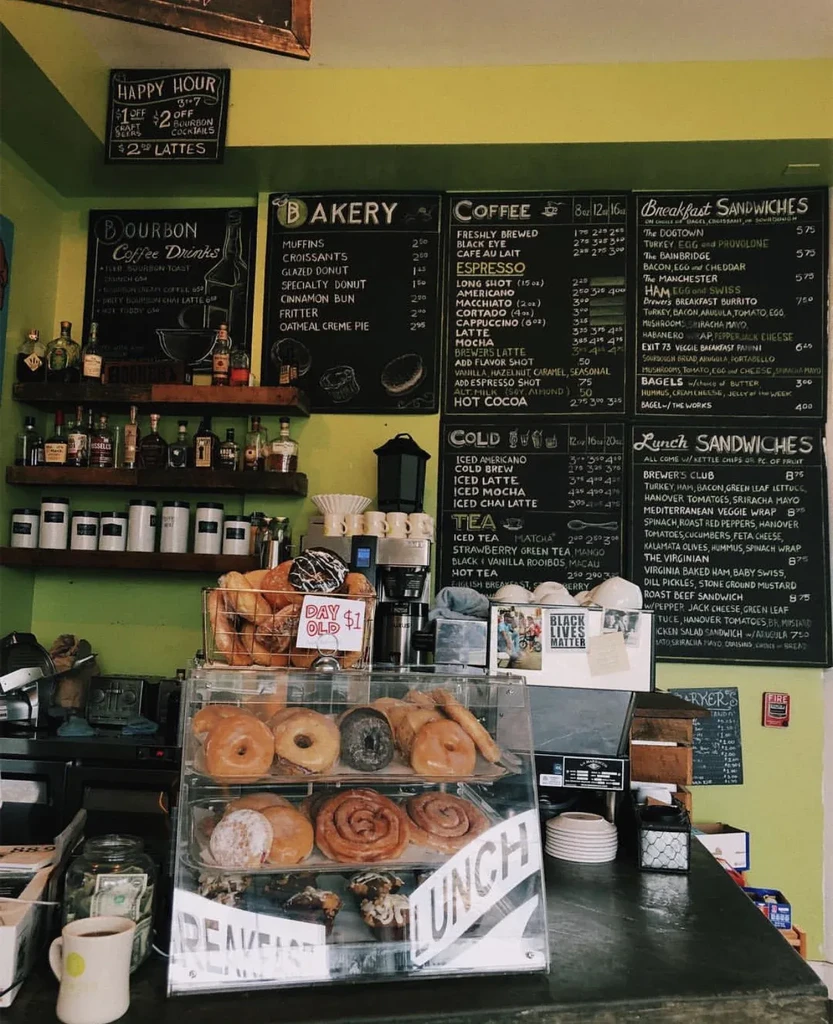 Lime green cafe counter displays pastries, coffee, and chalkboard menus.