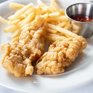 Crispy chicken tenders, french fries, and ketchup on a white plate.