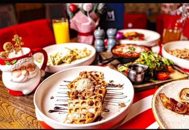 Christmas table spread with waffles, gingerbread, and other dishes.
